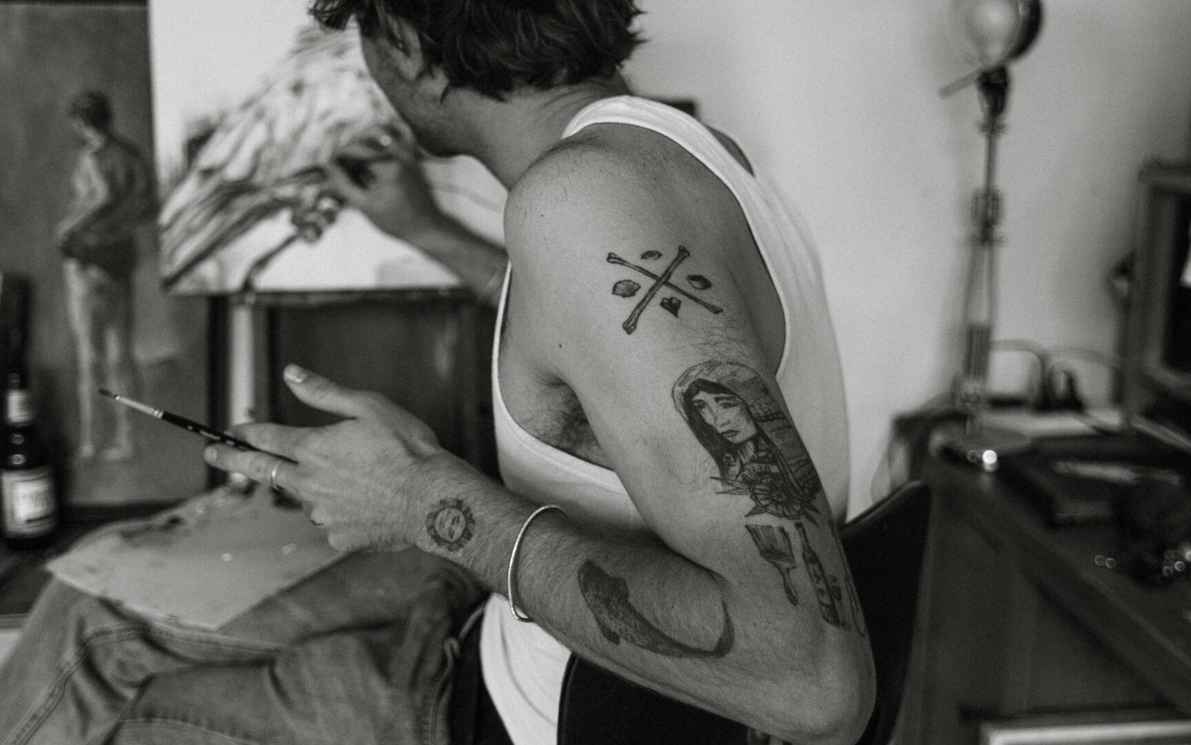 Tattoo artist, piercing parlor, black and white, artist sitting backwards